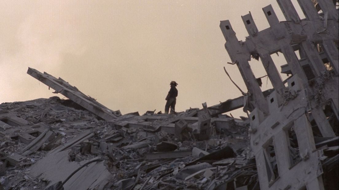 A firefighter stands on the debris pile at Ground Zero