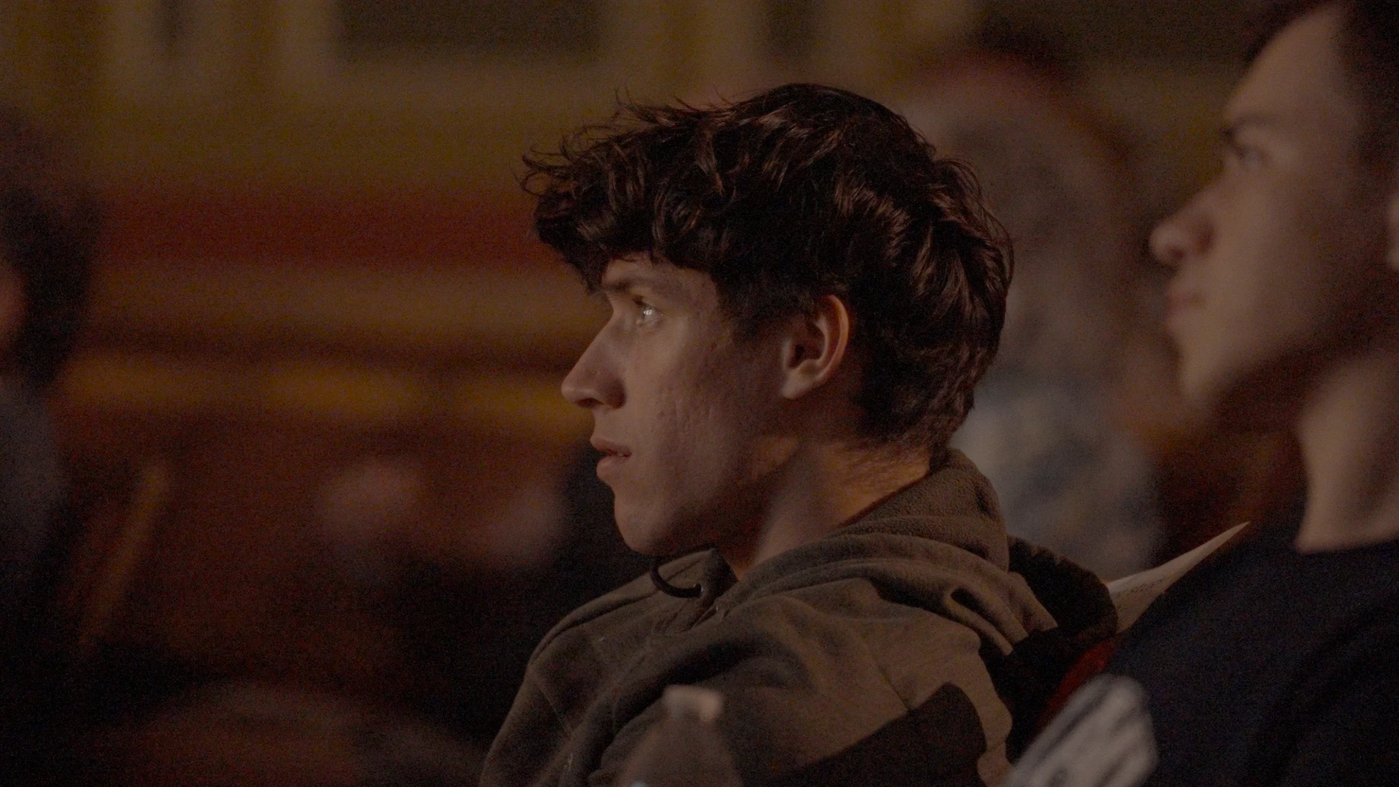 A student listens intently in a darkened room